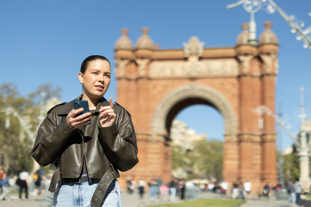 Young woman with phone in front of Triumphal Arch