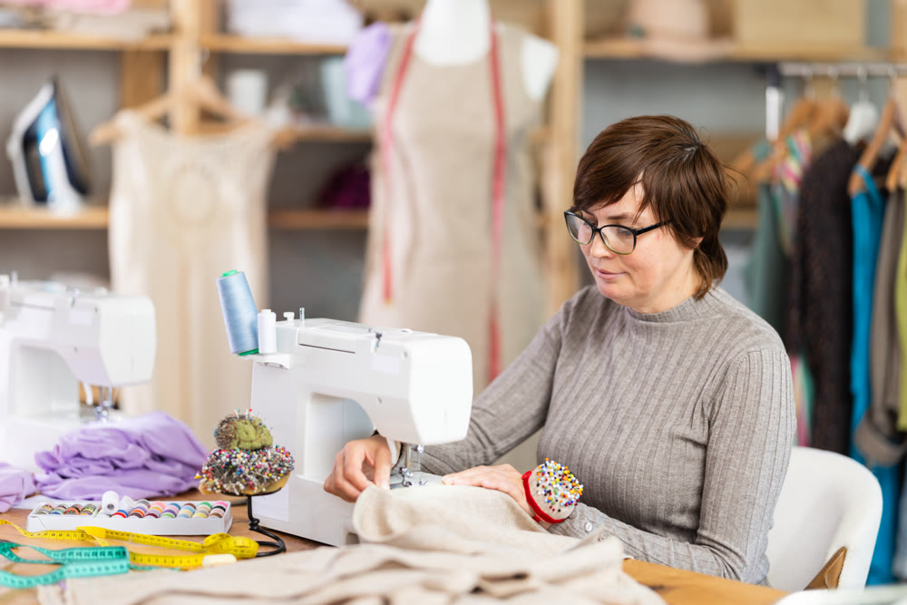 Woman tailor sews clothes in sewing machine