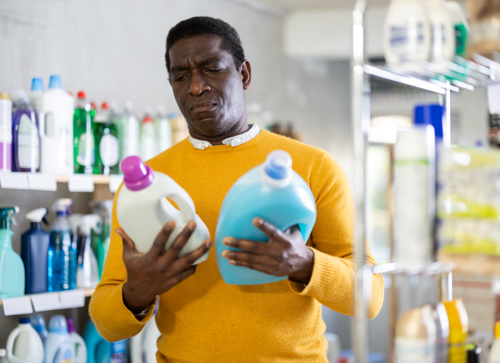 Male consumer with household chemical products for washing indoors
