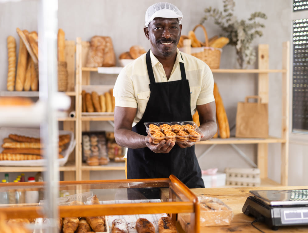 Smiling baker offers to buy fresh hot croissants