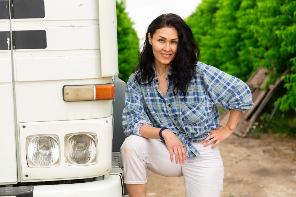Woman is standing beside the truck