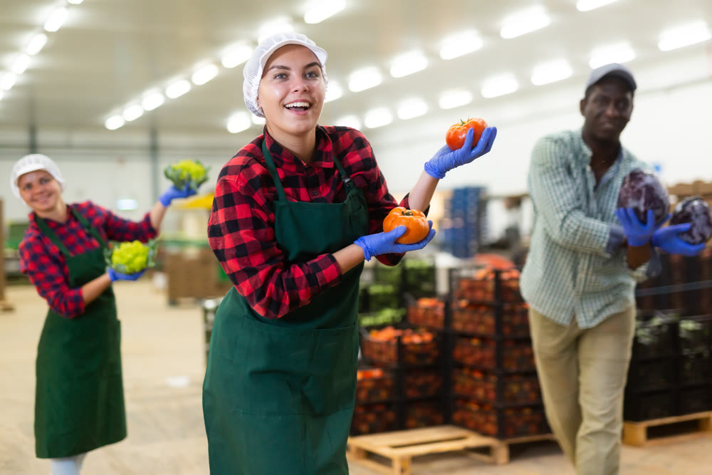 Vegetable factory workers performing funny dance with vegetables