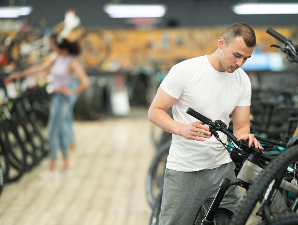 Young man choosing bike in store