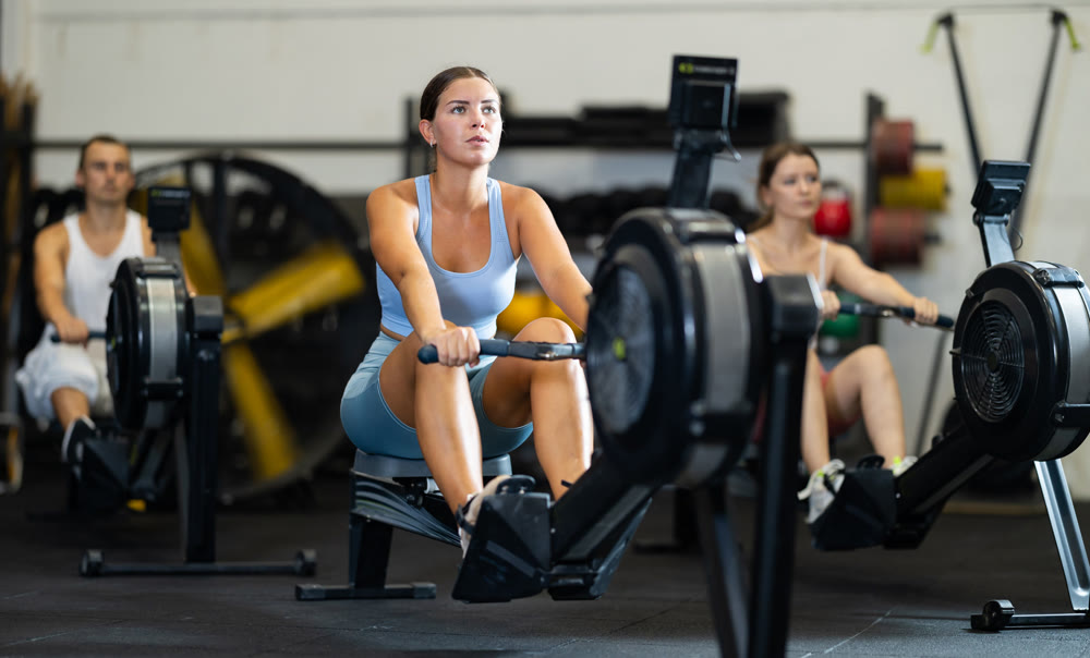 Young woman exercising on rowing machine