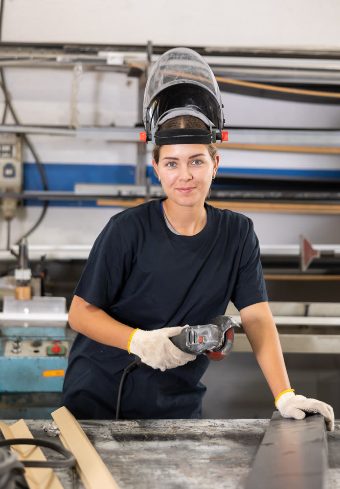 Male worker cutting aluminum profile using angle grinder