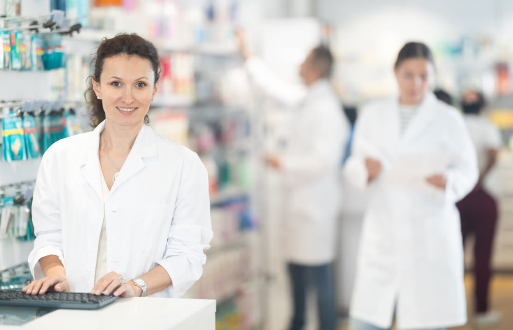 Portrait of friendly female pharmacist at the cash register in pharmacy