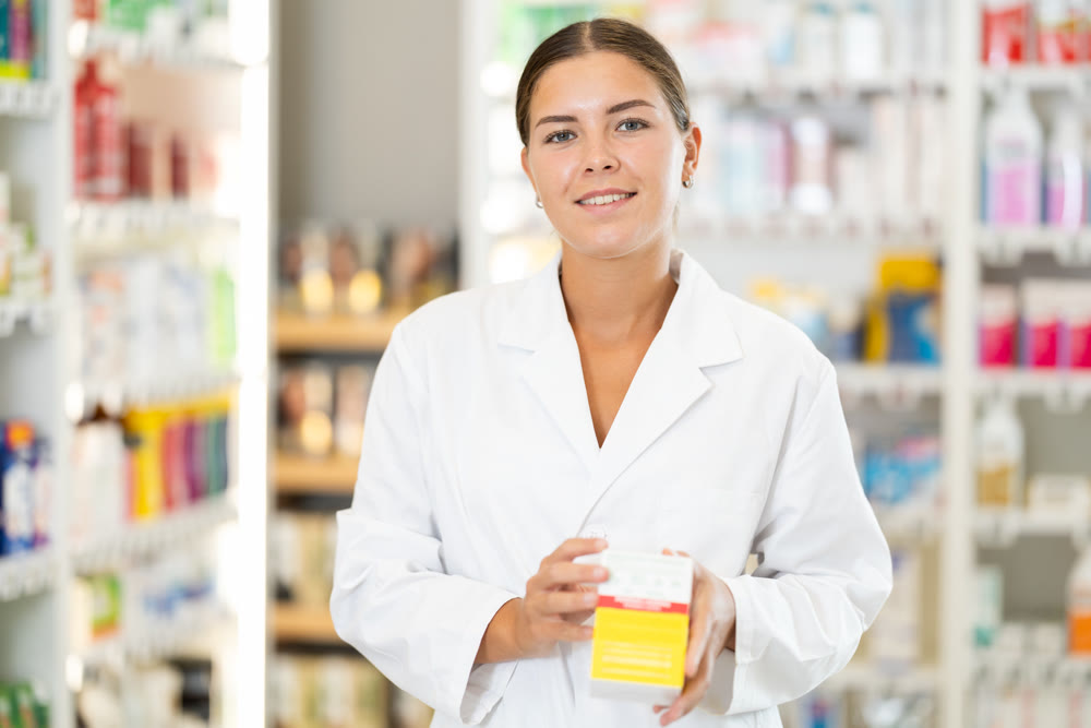 Young female pharmacist offering preparation in box