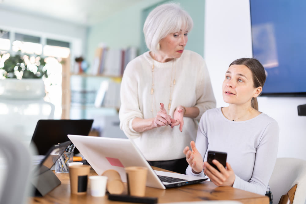 Senior woman boss found female subordinate idling and scrolling phone, mentor shouts at subordinate.