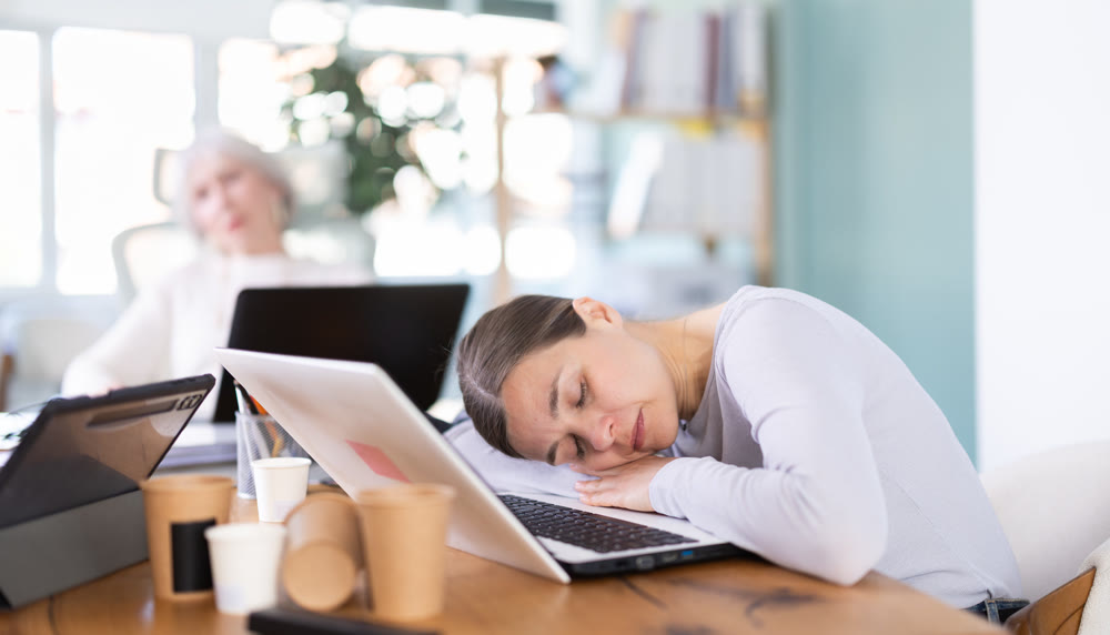 Tired businesswomens sleeping in the office with her head on table