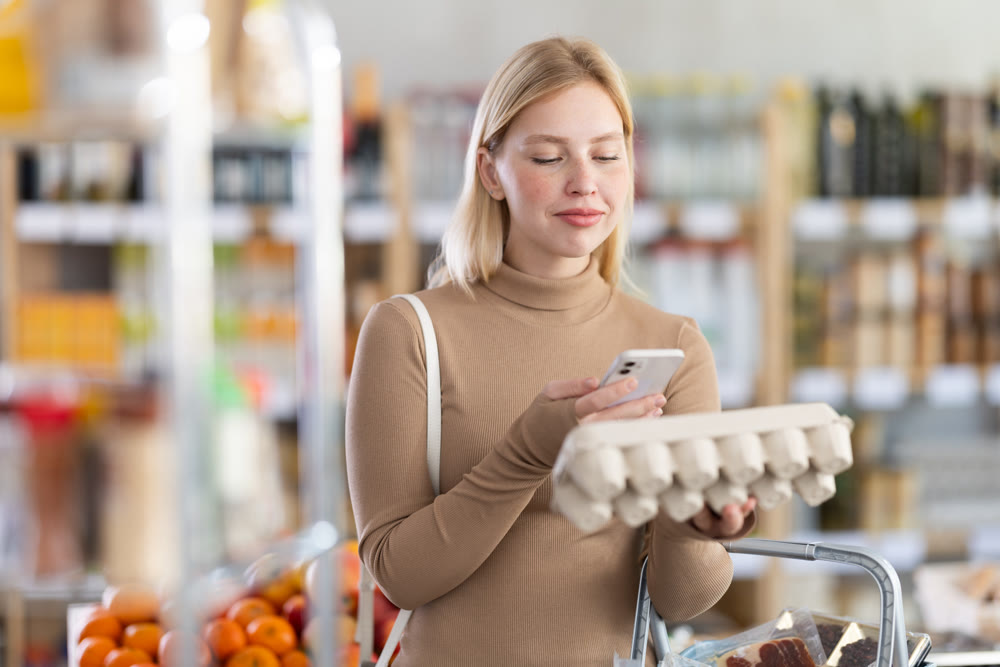 Young woman scanning qr code of eggs