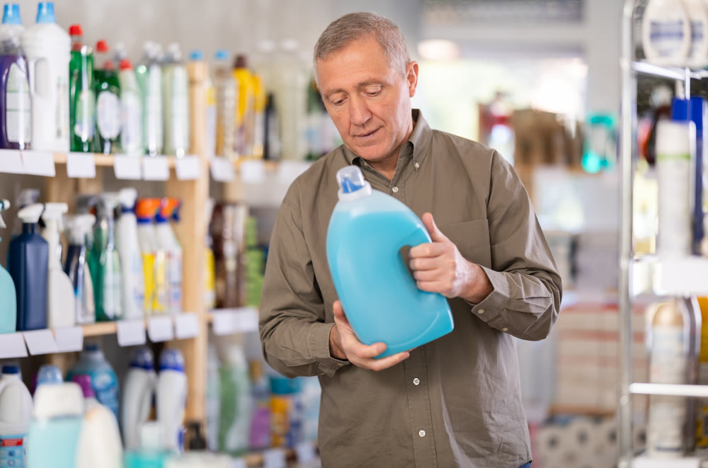 Male consumer with household chemical products for washing indoors