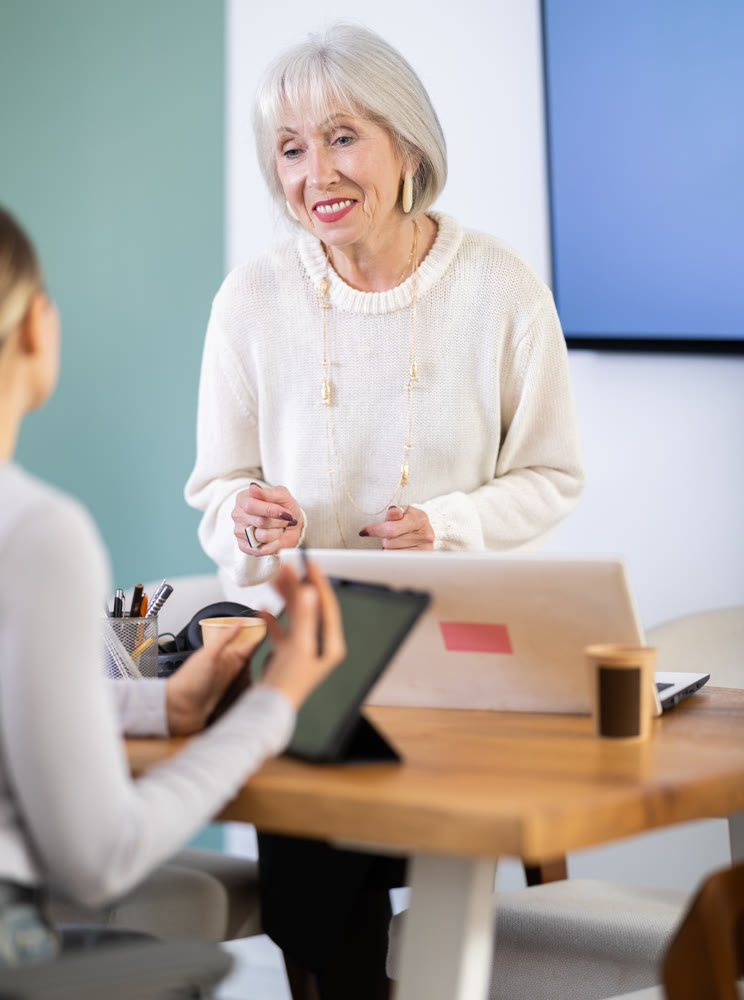 Elderly and adult women working in office