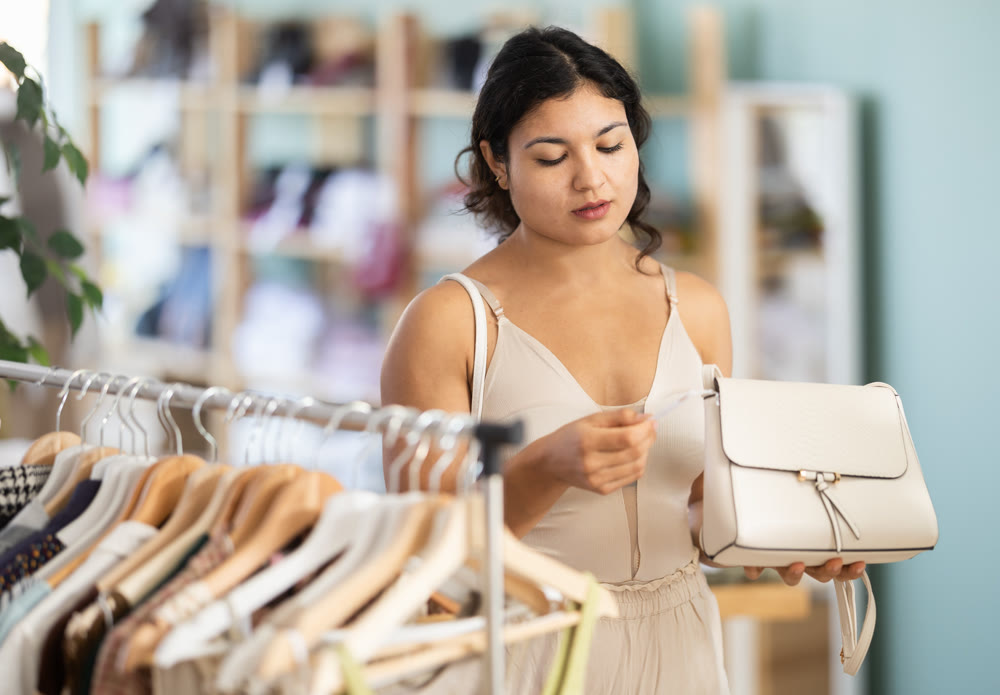 Young women choosing handbag in store