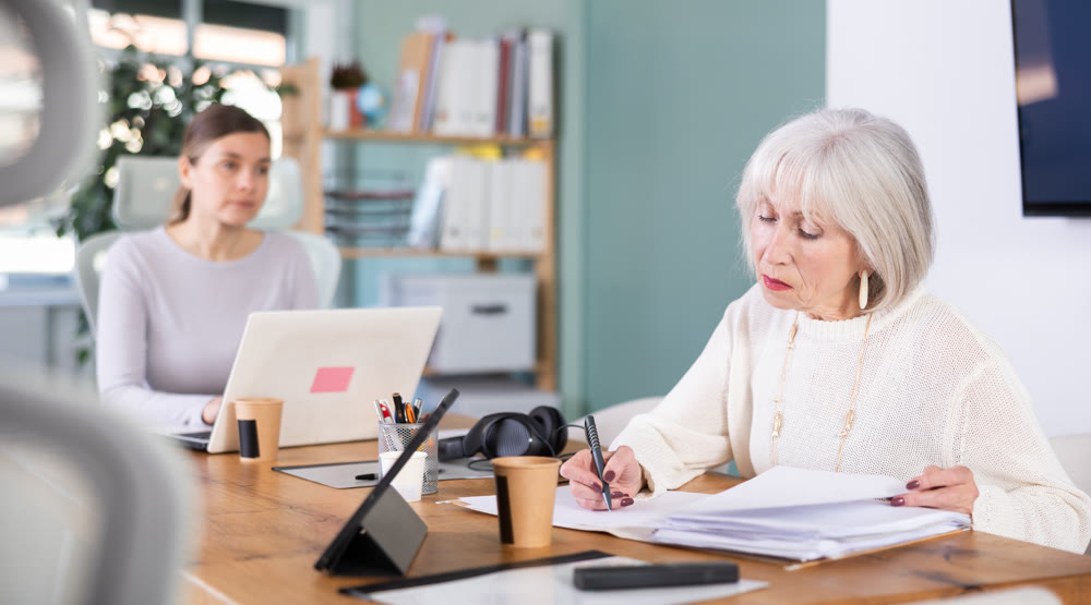 Senior woman working, fill in document in office