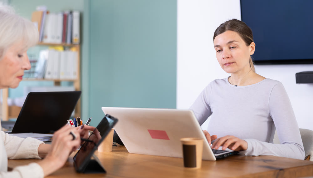 Elderly and adult women working in office