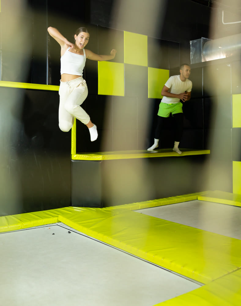 Excited young girl jumping at indoor trampoline center