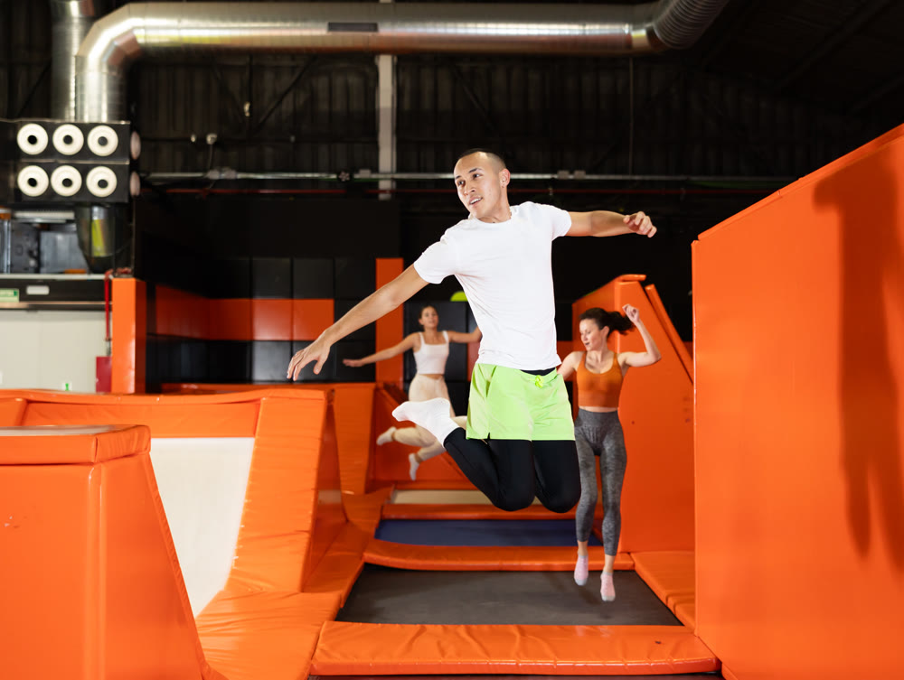 Male athlete training to jump on trampolines at trampoline center