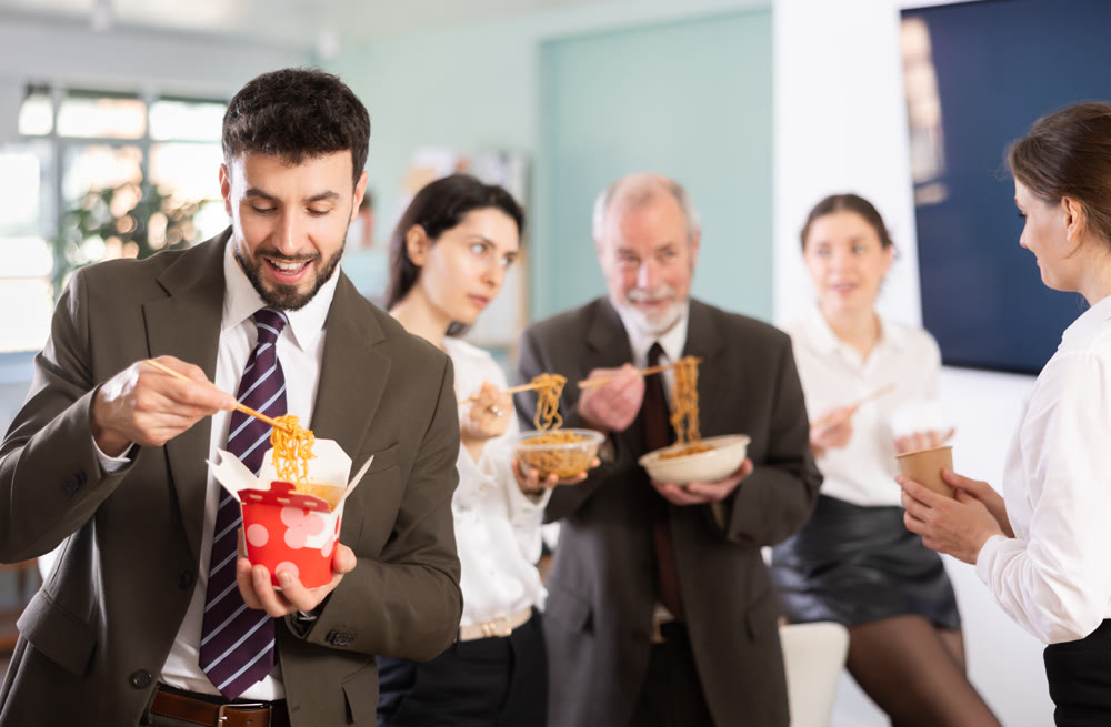 Male companys employees eat instant noodles, lunch time during break for staff