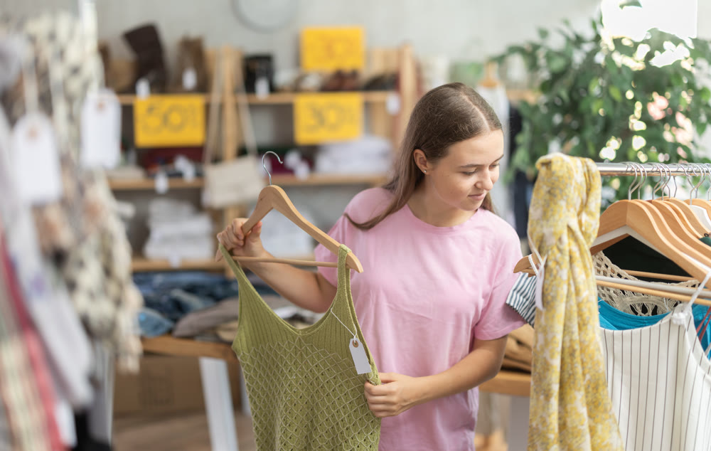 Teenage girl choosing top in clothing store