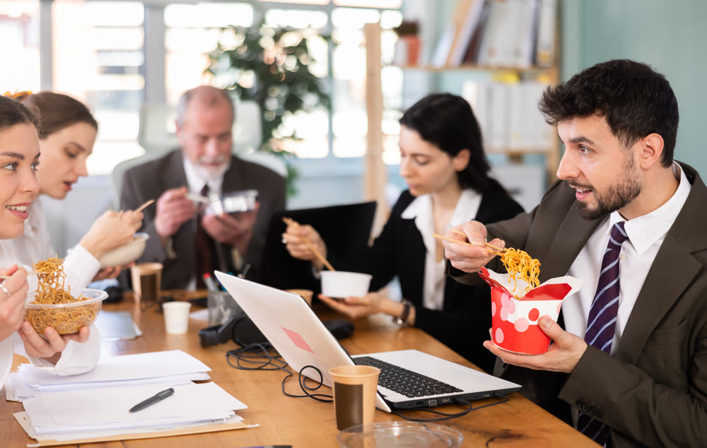 Male companys employees eat instant noodles, lunch time during break for staff