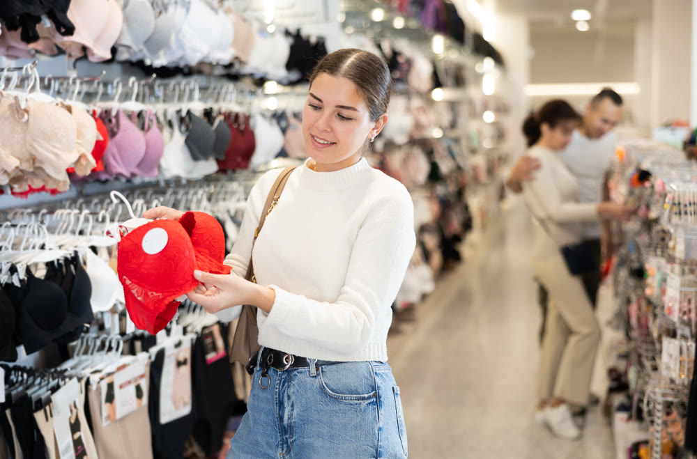 Young woman choosing bra in store