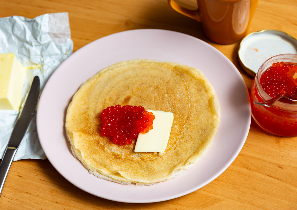 Pancakes served with red caviar and butter