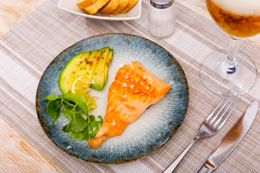 Salmon with avocado slices and lime