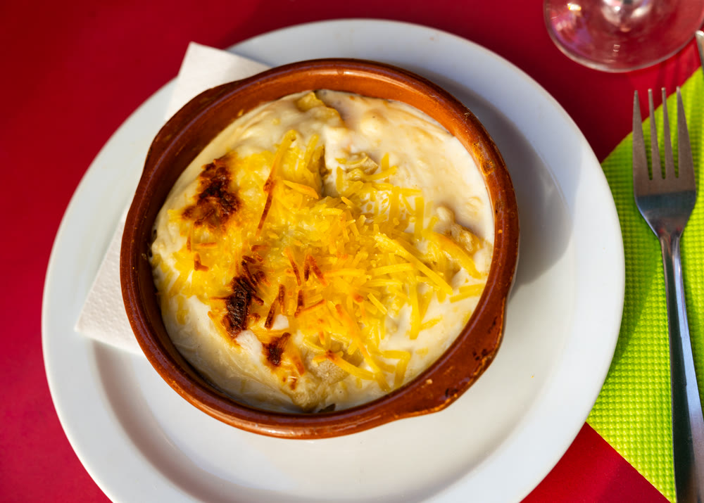 Traditional Cannelloni stuffed with minced meat baked in bechamel sauce with grated cheese