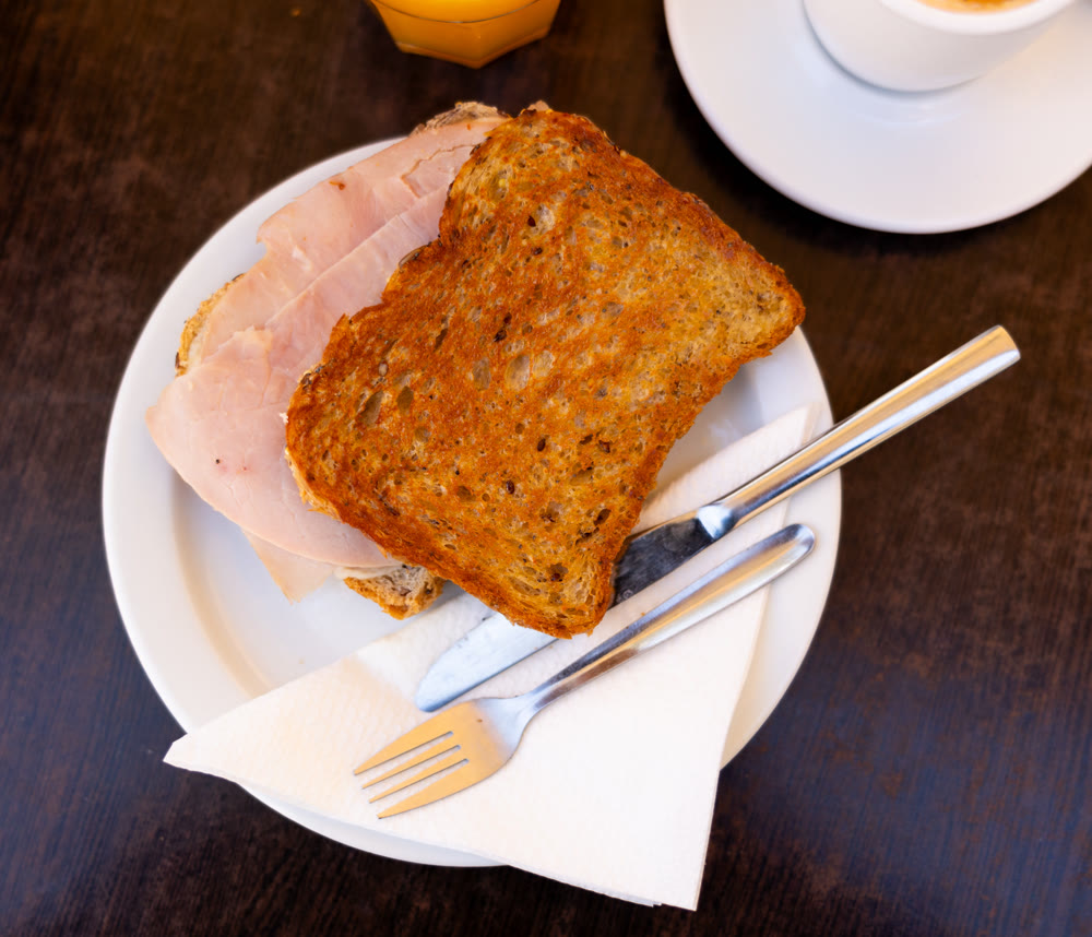 There is thin slice of soft and juicy ham between two slices of bread.