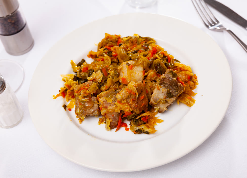 Appetizing cabbage stewed with pork meat on plate