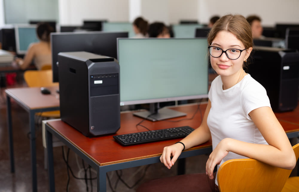 Portrait of interested teen girl during lesson in computer room of school class