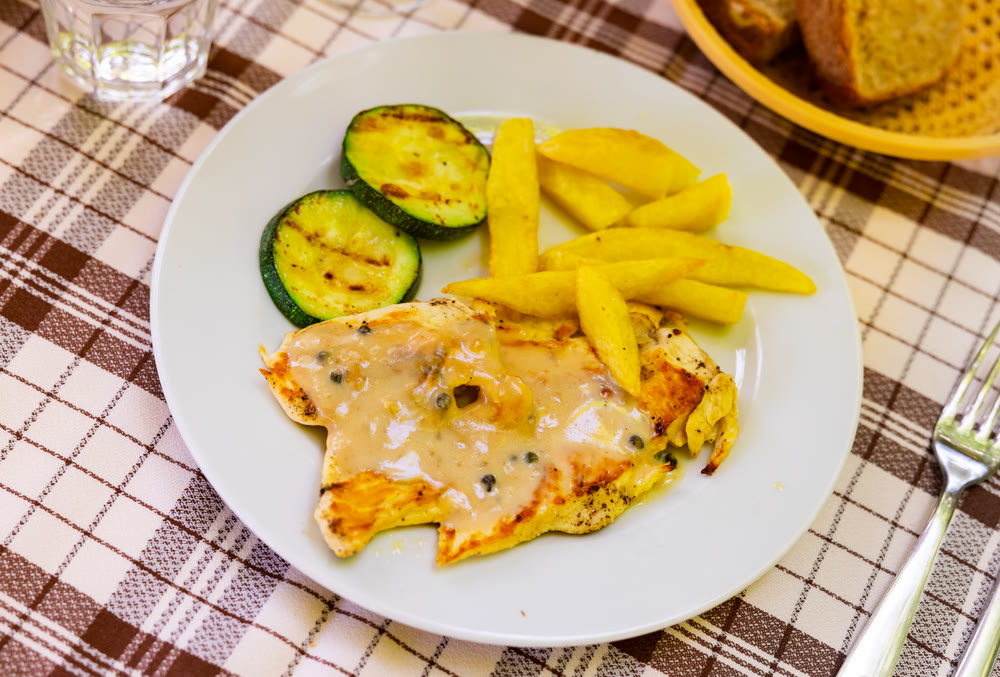 Tender meat of baked chicken breast with pepper garnished with French fries