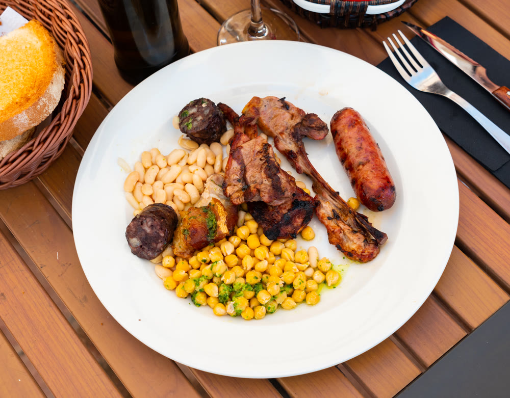 Grilled meat served with beans and chickpeas