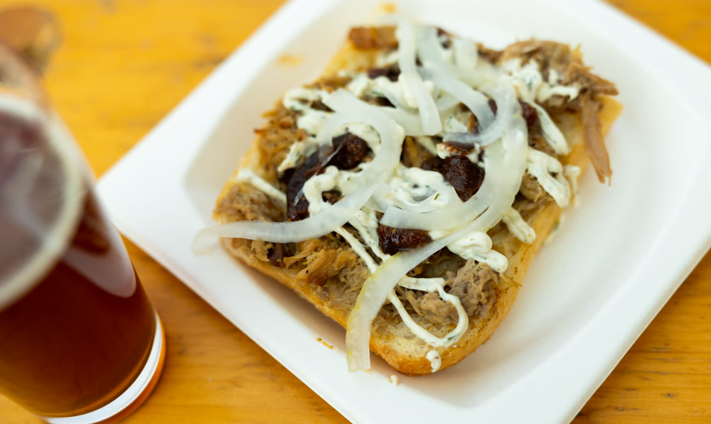 Sandwiches with lamb, sauce and onion served on white plate