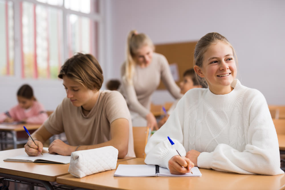 School lesson - students write down assignments while sitting at desks