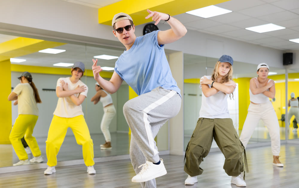 Young guy in sunglasses dancing modern dance