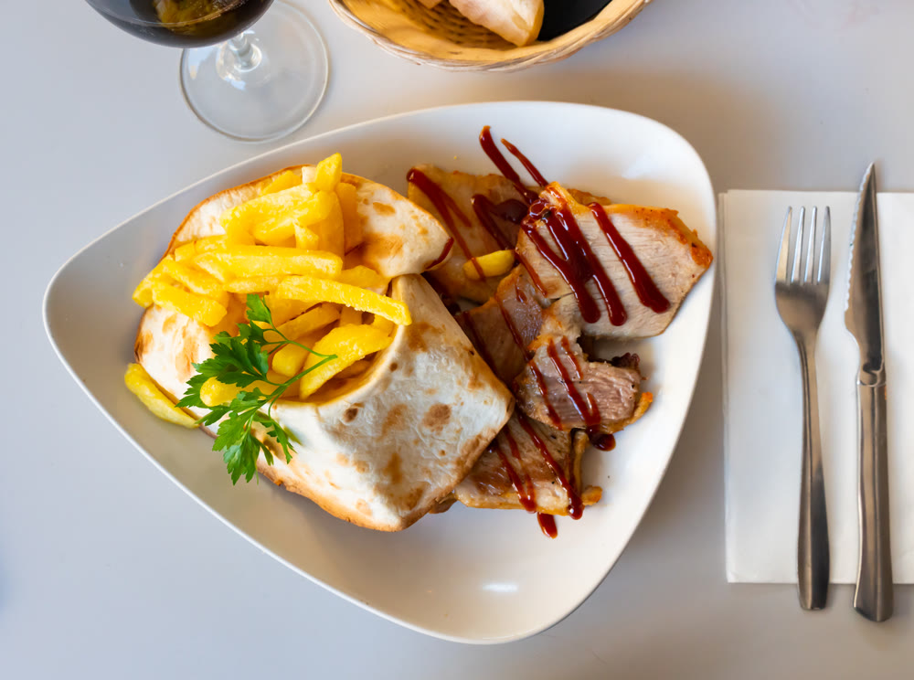 Pork secret served with potatoes on platter
