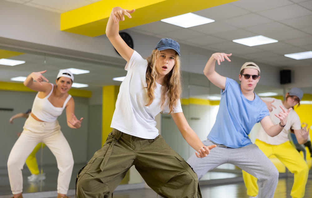 Teen girl in cap dancing modern dances