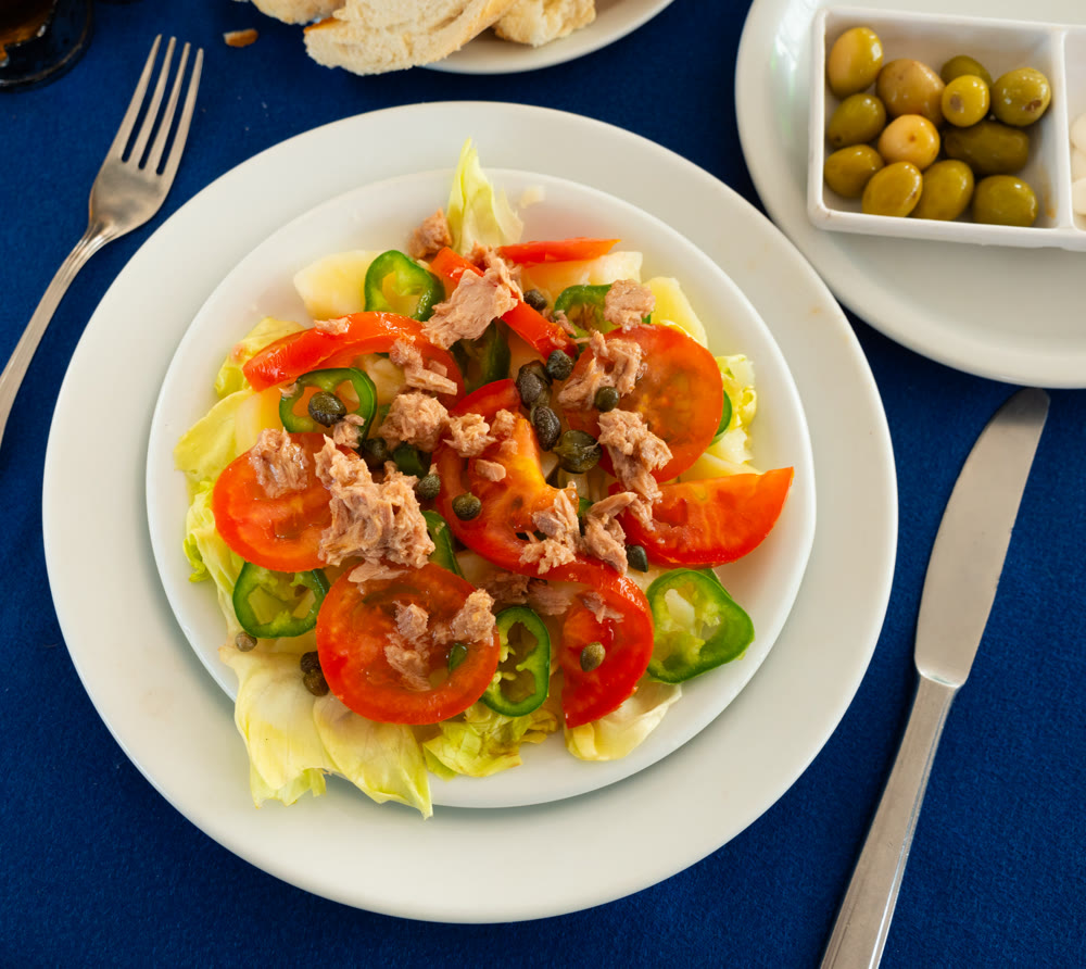 Traditional Tunisian salad with vegetables, olives, tomatoes and tuna closeup