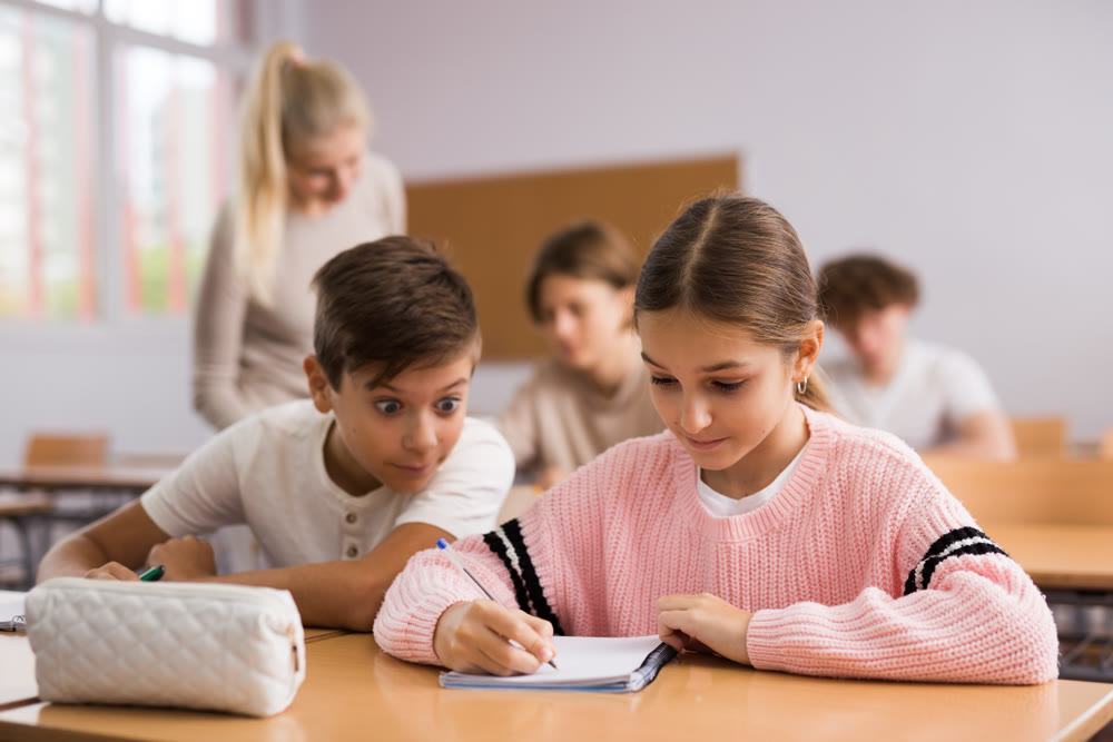 Group of students working at class, listening explanations of teacher in classroom