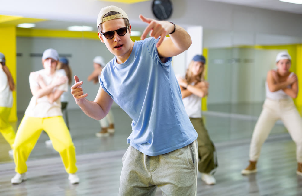 Young guy in sunglasses dancing modern dance