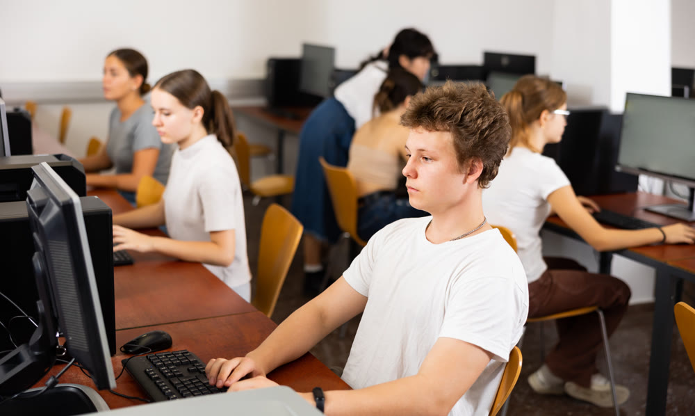 Clever focused male teenager solving tasks of computer science in the auditory