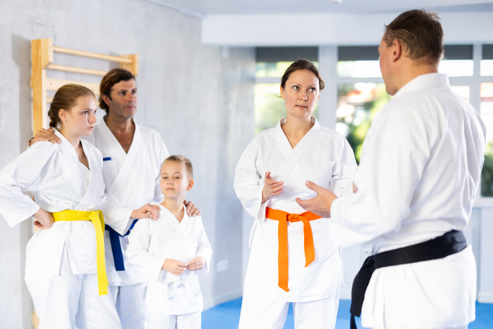 After completing family session and karate training, parents talk with male coach.