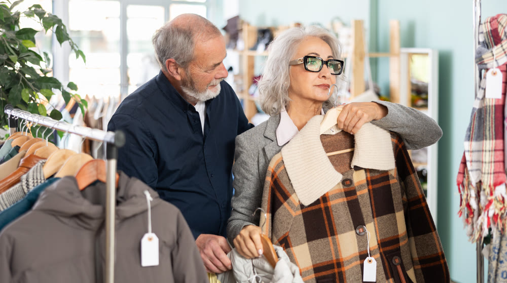 Elderly couple choosing jackets and coats together