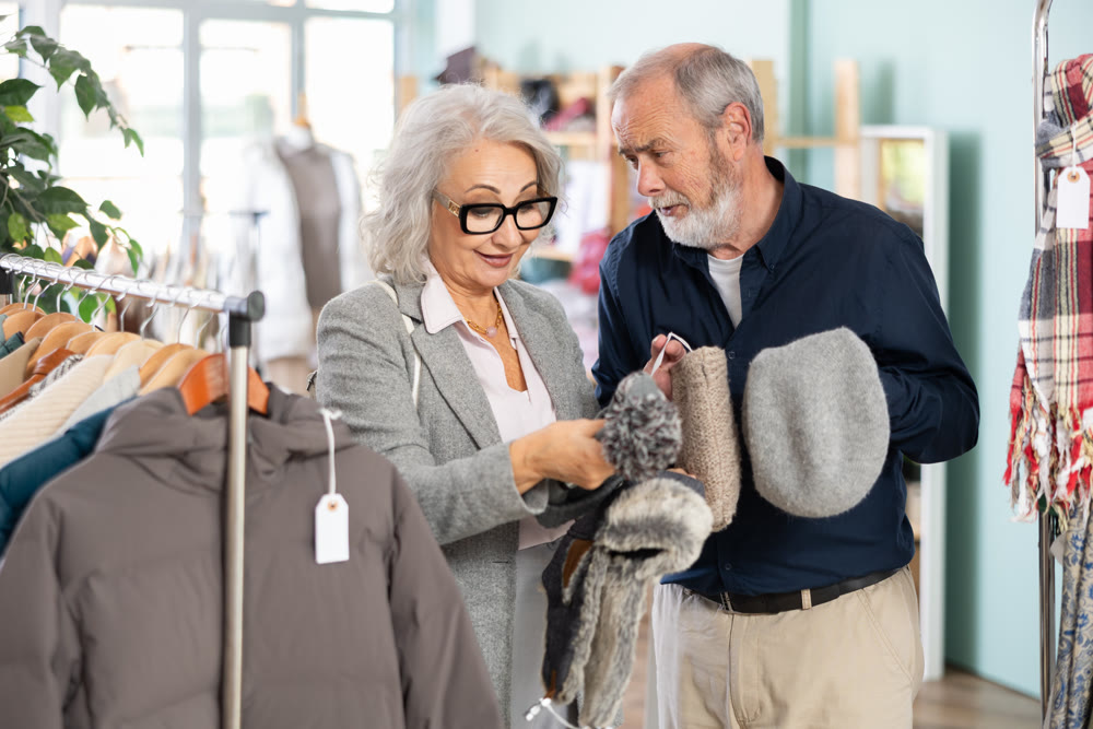 Mature couple spend time in shop and choose winter hat