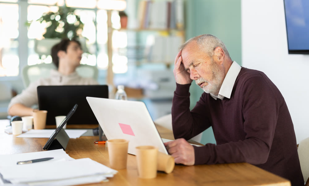 Tired male office workers having nap while sitting in workplace