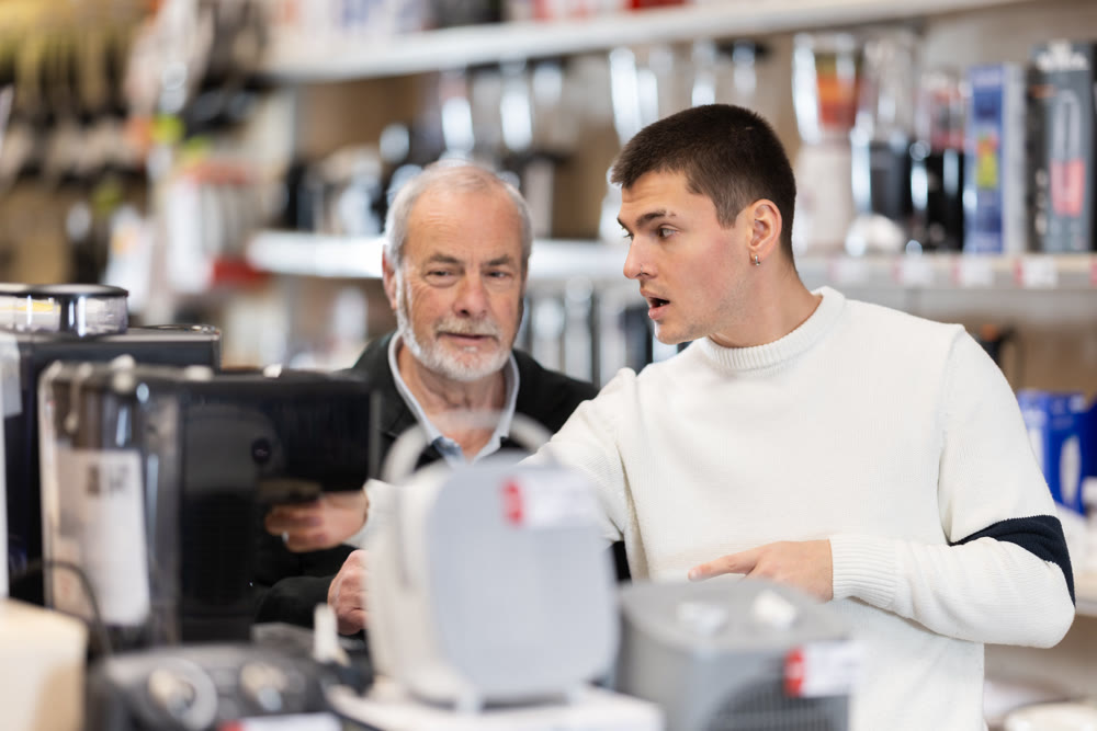 Eldery and young man choosing coffee machine