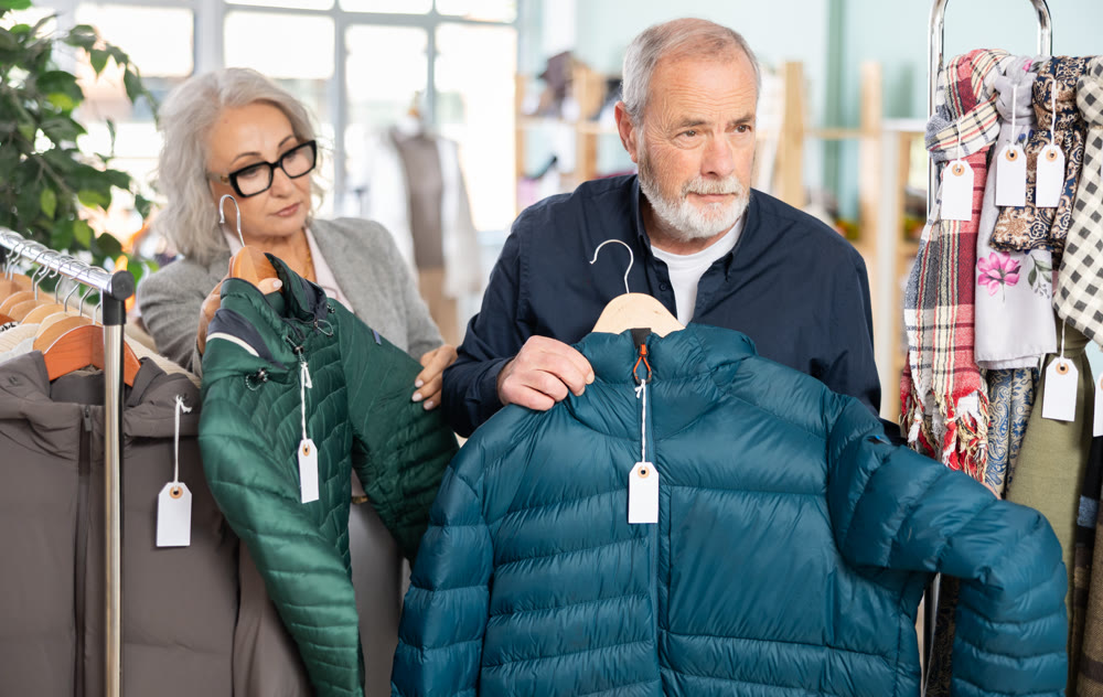 Family clothing store, senior couple customer chooses down jacket
