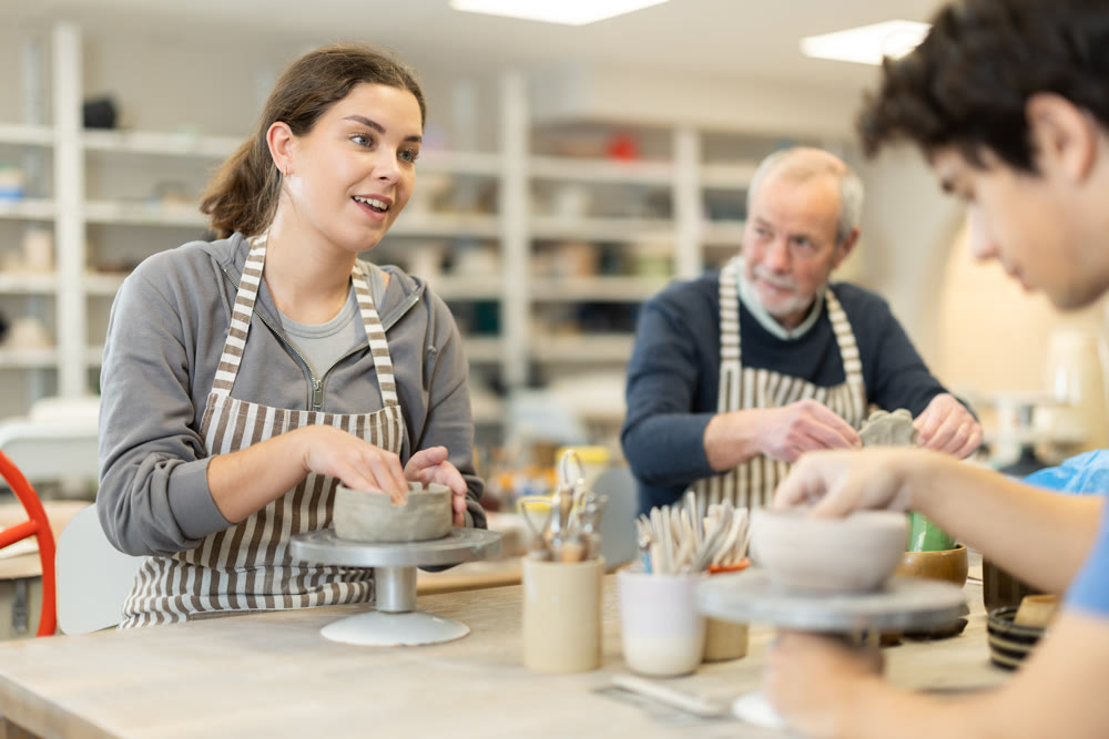 Young woman and man and elderly man crafting ceramics