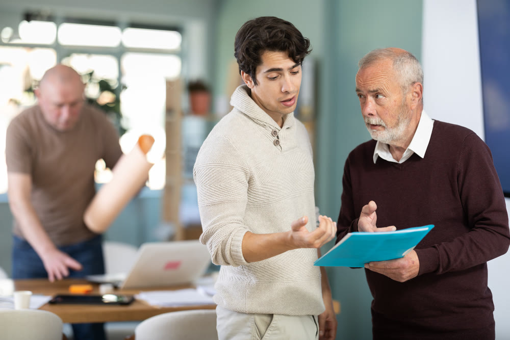 Men with papers in hands talk and discuss working issues